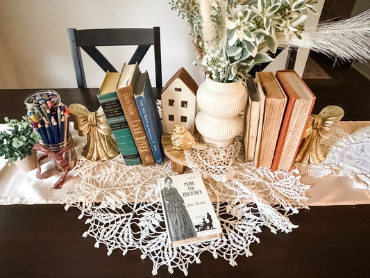 Pride and Prejudice on a table decorated with lace and old books